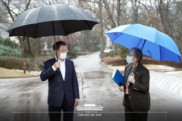 문재인 대통령이 15일 청와대 여민관 앞에서 정은경 질병관리청장과 우산을 쓴 채 이야기를 나누고 있다. [사진=청와대]